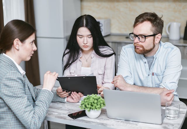 A landlord going over a lease agreement with two tenants